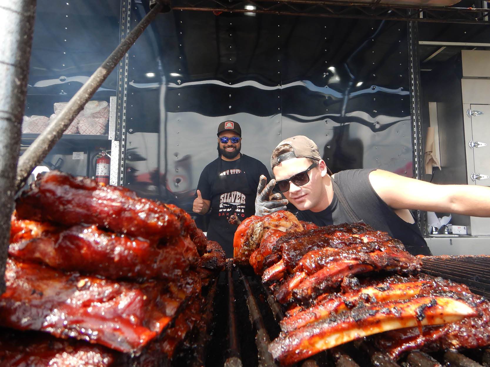 Two men serving ribs